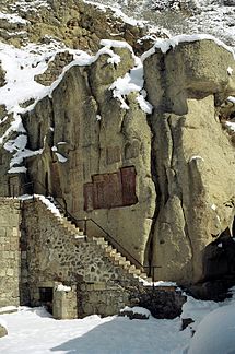https://upload.wikimedia.org/wikipedia/commons/thumb/8/81/Geghard_monastery_wall.jpg/215px-Geghard_monastery_wall.jpg