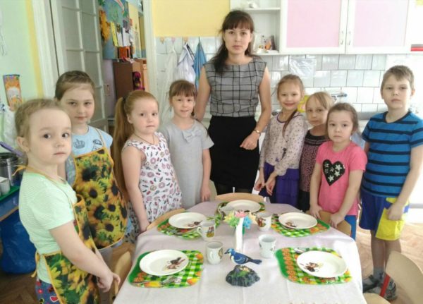 Педагог и дети перед сервированным столом