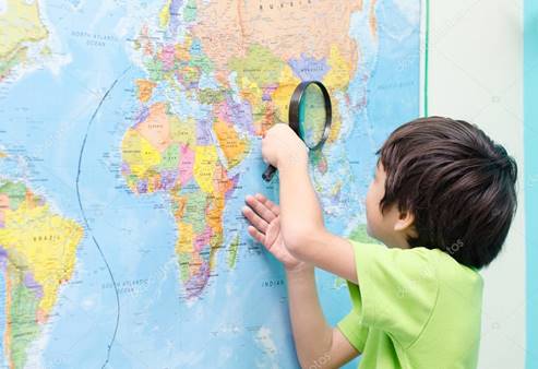 Little boy using magnify looking on map Stock Photo by ©wckiw 57126395